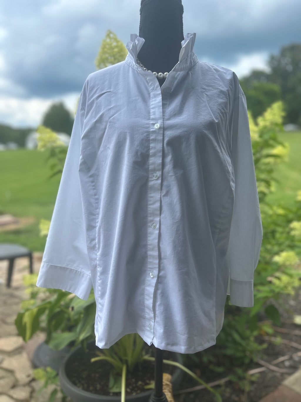 Crisp white cotton blouse with a feminine ruffled stand collar.